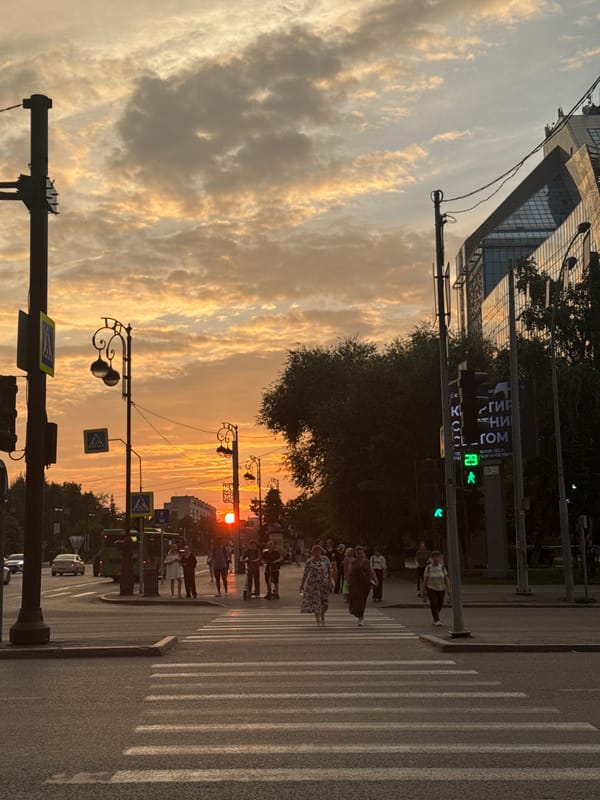 Golden sunset over Tyumen streets, traffic rolling through