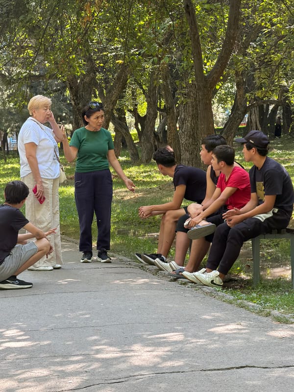 Casual park scene with visitors and a grounds worker