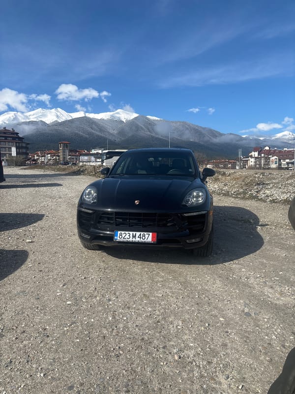 Black Porsche parked on gravel road in Bansko Bulgaria