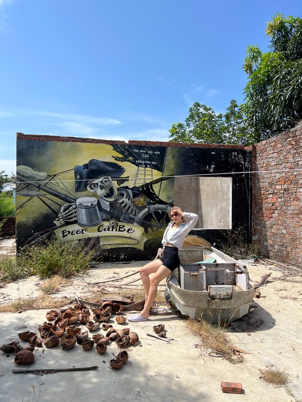 Tourist poses for photo at street mural in Đà Nẵng