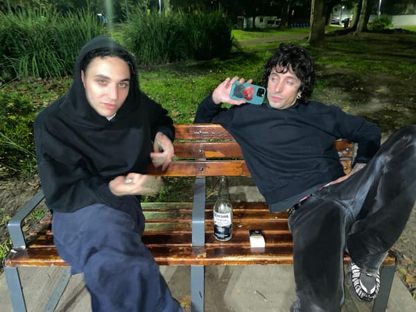 Two men sit on bench in Buenos Aires early morning