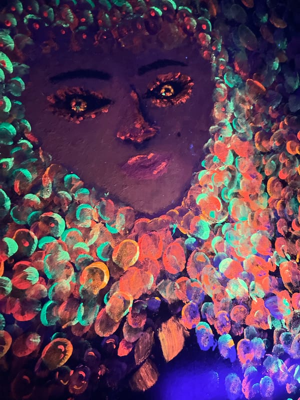 Woman drinks orange beverage near glowing artwork in Chaikovsky