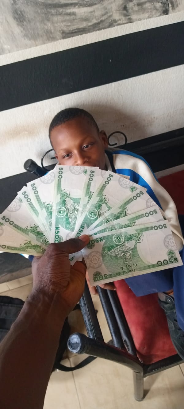 Boy photographed with Nigerian Naira notes displayed in foreground
