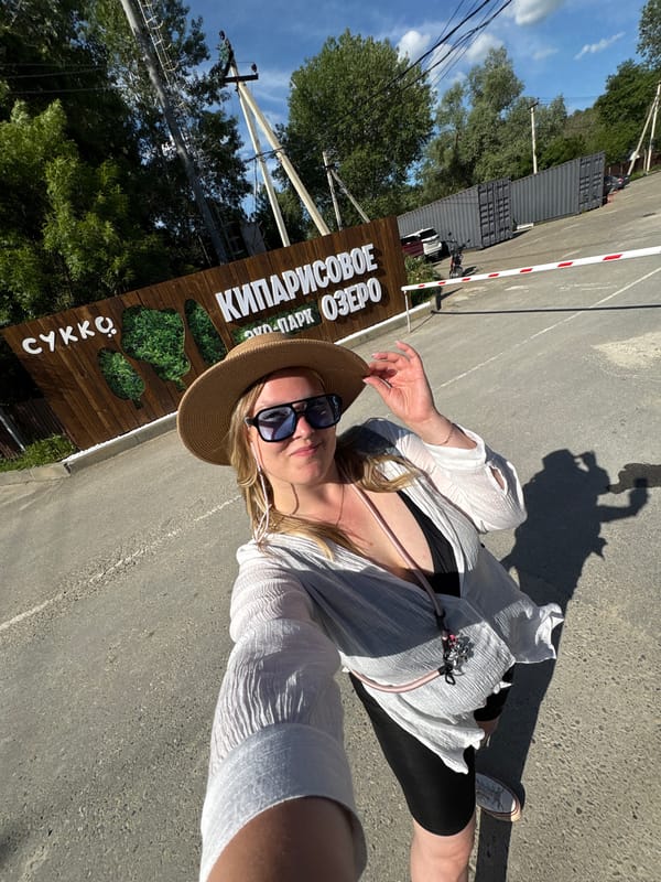 Women take sunny outdoor selfies at checkpoint entrance