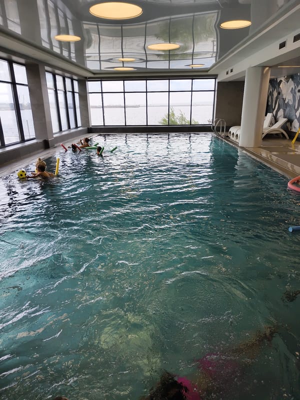 Indoor pool fun with kids and selfies, harbor views outside