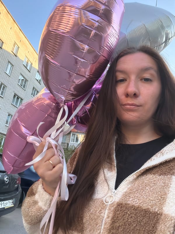 Woman holds heart-shaped balloons in sunny Tokkari, Russia