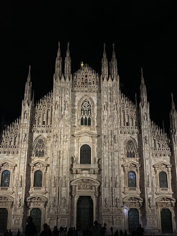 Evening crowds gather around illuminated Milan cathedral and gallery