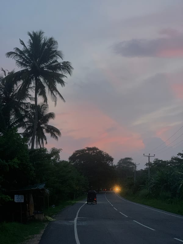 Vehicle travels scenic sunset road in Batawala, Sri Lanka
