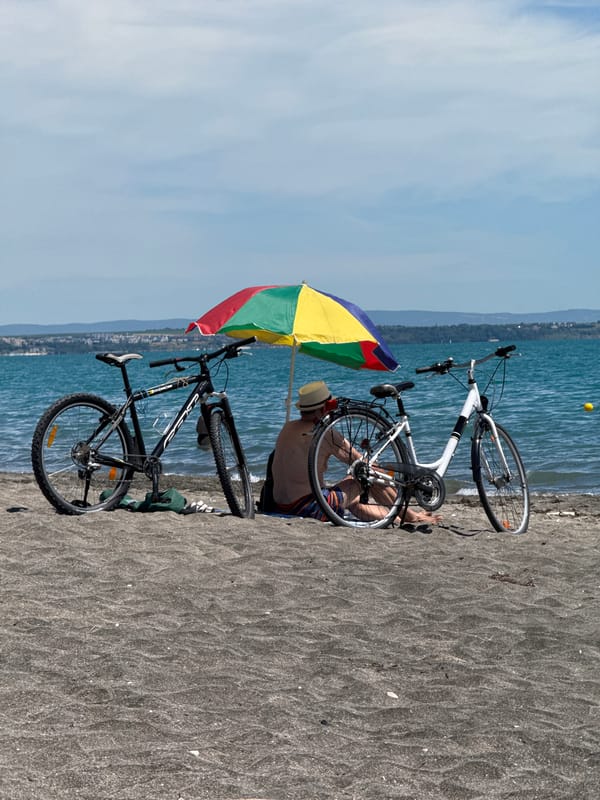Bikes parked, umbrella up, eyes on the water in Burgas