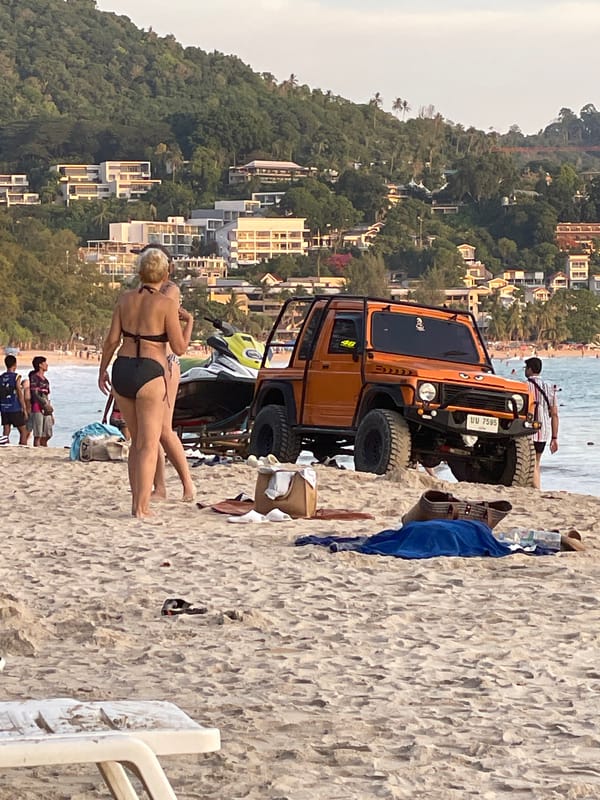 Tourists relax on Karon Beach facing Andaman Sea