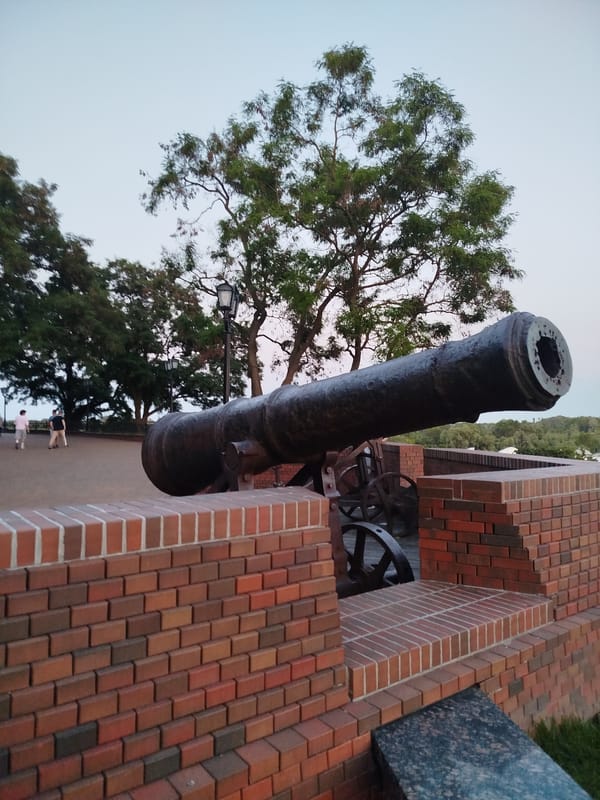 Chernihiv's hilltop park at dusk, cannons and golden domes