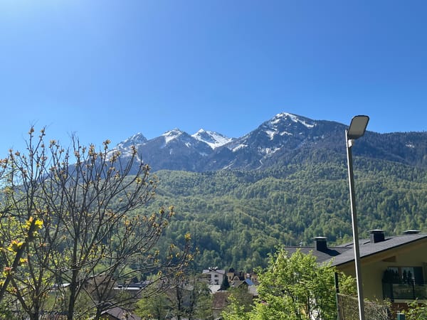 Mountain landscape with snow-capped peaks observed over residential area