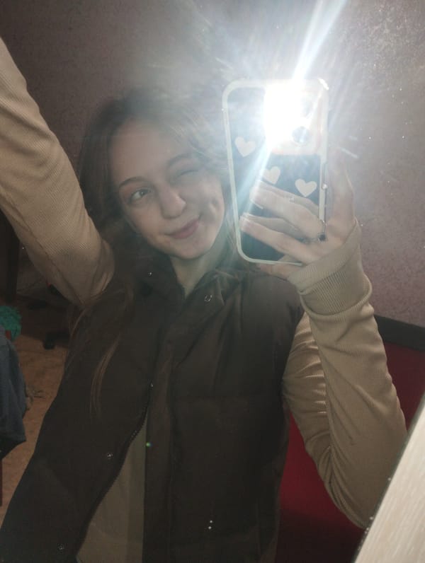 Young woman takes selfies in bedroom mirror in Saratov