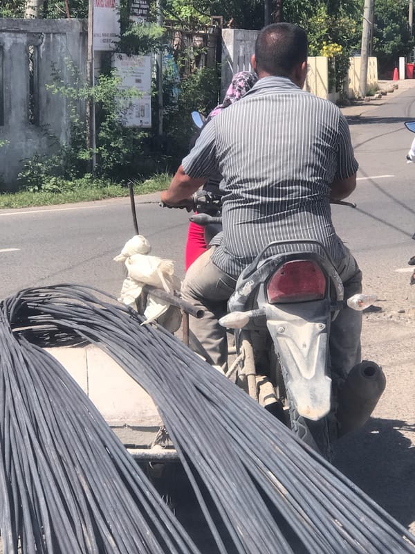 Motorcyclist transports steel bars in Lhokseumawe, Indonesia