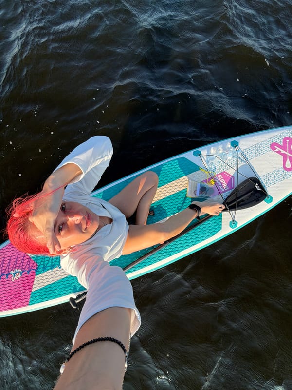 Overhead view of paddleboard rest on dark rippling water