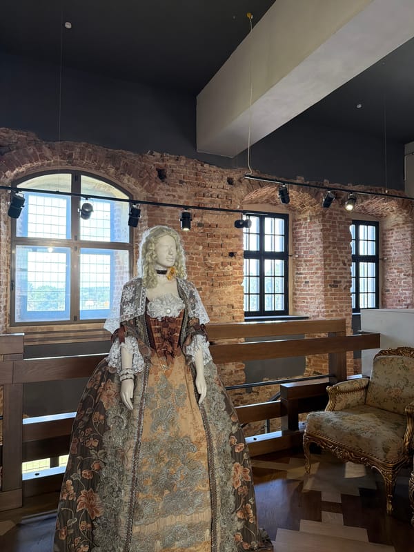 Inside a historic castle or palace museum with period rooms and armor