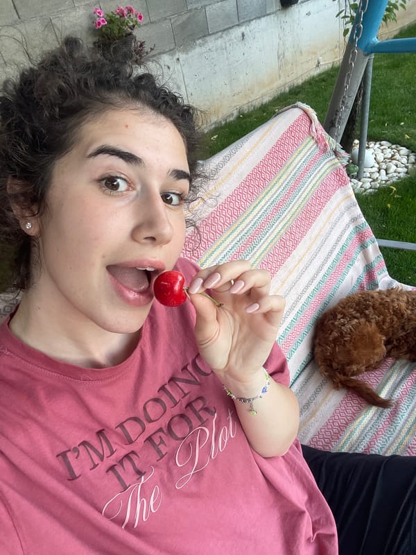 Woman enjoys cherries with sleeping poodle in Sofia park