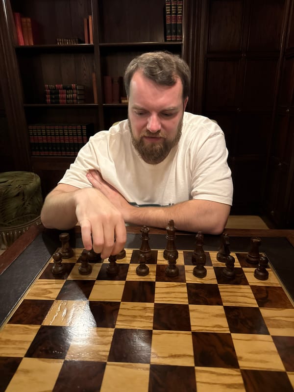 Cape Town evening: chess player indoors, wet restaurant tables outside