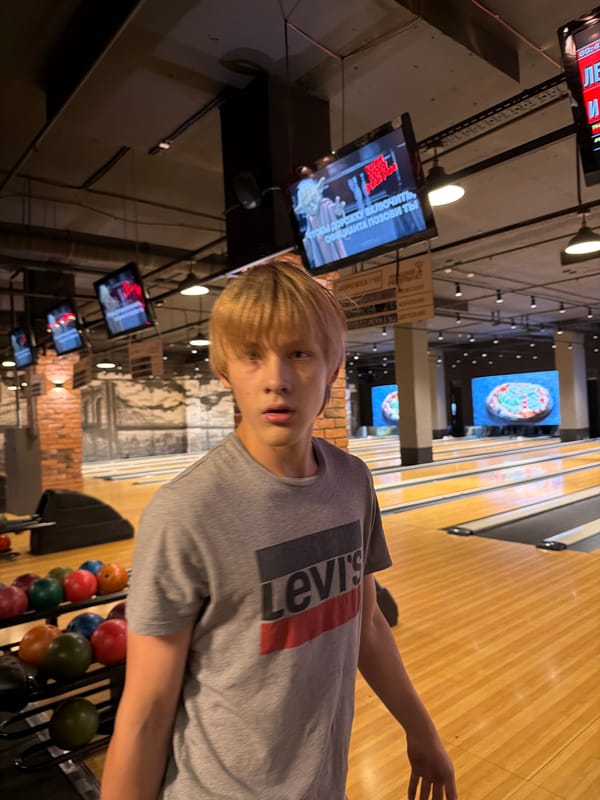 Bowling session at an Izhevsk alley, red ball mid-throw