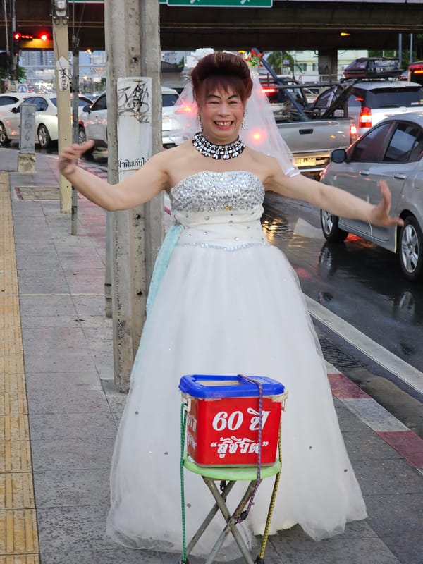 Wedding gown on a Bangkok sidewalk, arms wide open