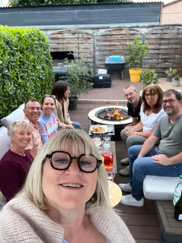 Eight gather around fire pit with drinks in Veauche