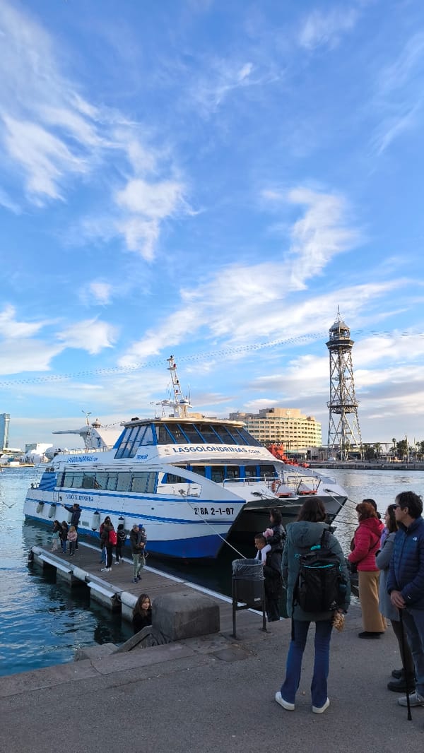 Barcelona waterfront buzzes with tourists, street performers, monument visitors