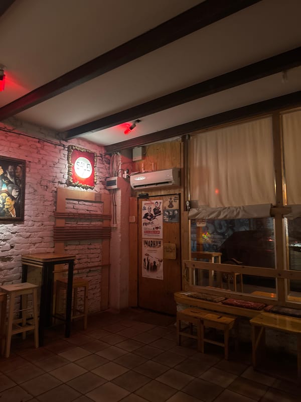 Person photographed at dimly lit Sofia establishment wearing yellow sunglasses