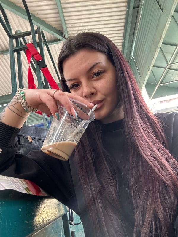 Woman drinks coffee at Sliven railway station early morning