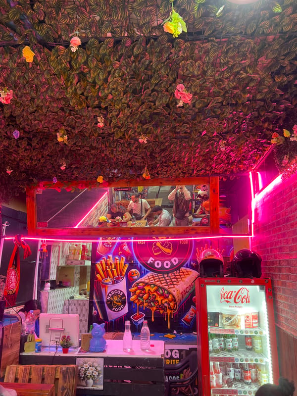 Food vendor in Dkhissa features pink neon, artificial foliage decor