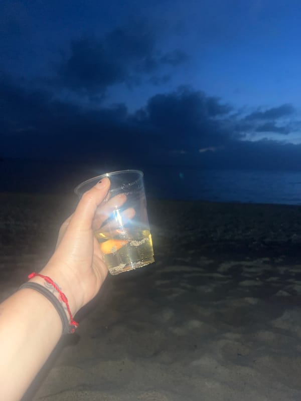 Evening beachgoer enjoys beverage under cloudy skies in Ascea