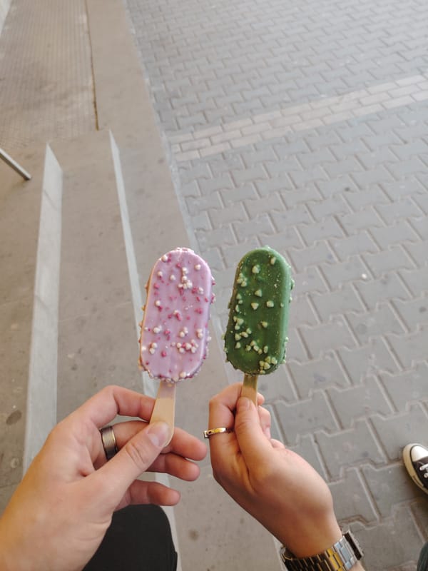 Two people share decorated ice cream bars outdoors