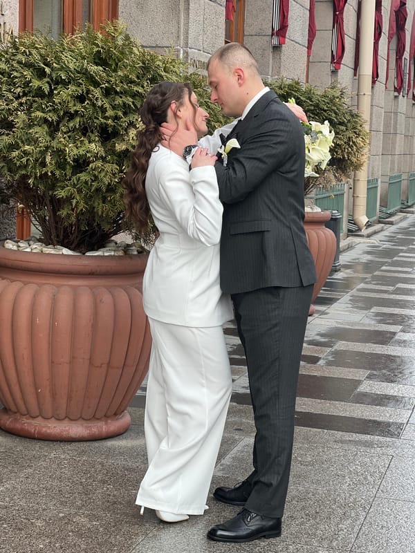 Newlyweds kiss on wet Saint Petersburg sidewalk