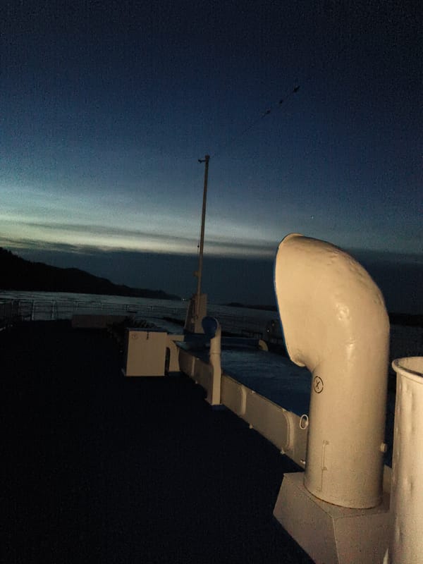 Ferry deck at dawn on a Russian river, hills on the horizon
