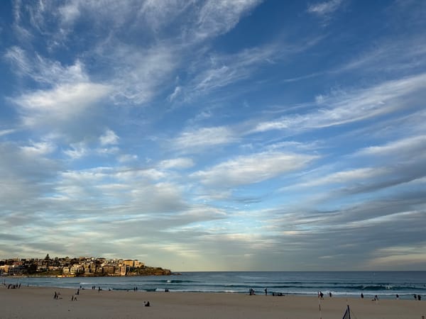 Bondi Beach under a cloud-streaked golden sky