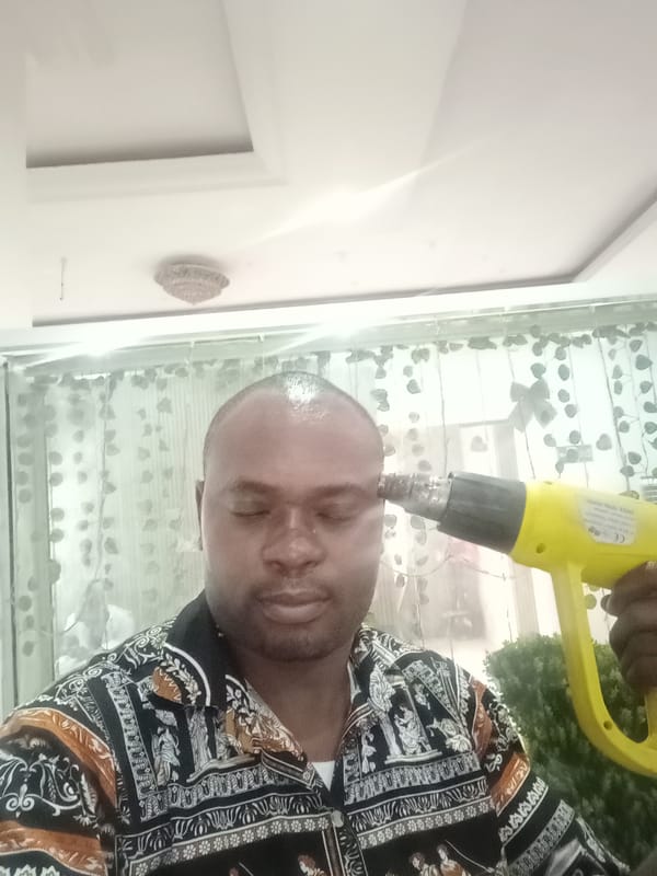 Man poses dramatically with heat gun in Gwarinpa, Nigeria