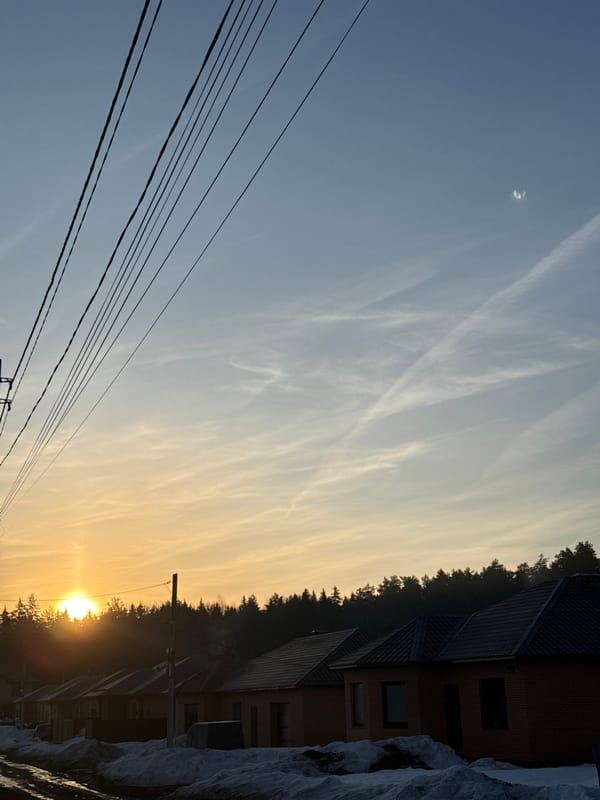 Sunrise observed in Chaikovsky, Russia with power lines, contrails