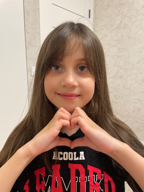 Girl poses for photo making heart gesture in Izhevsk