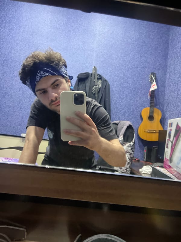 Young man takes mirror selfies in Tbilisi bedroom