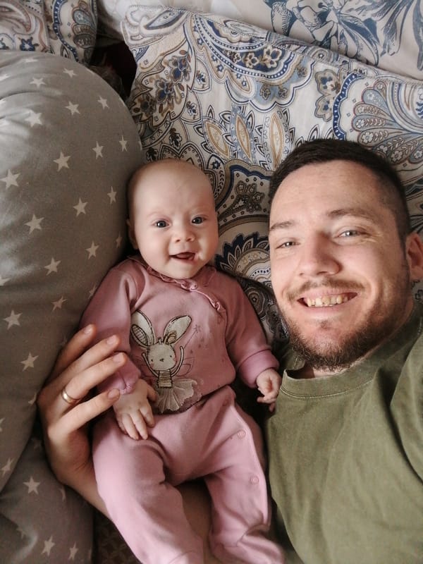 Father and baby share quiet morning moment in bed