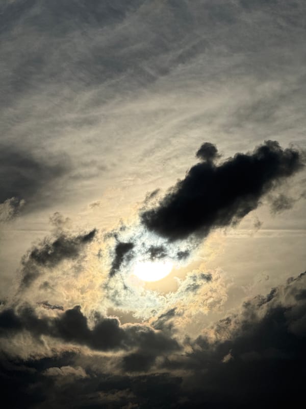 Stormy tropical sky, sun breaking through heavy clouds