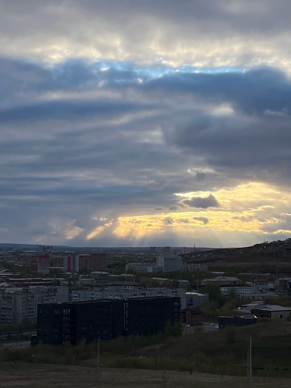 Dramatic sky with sun rays observed over Krasnoyarsk cityscape