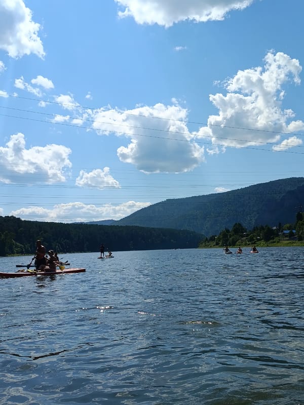 Summer day on the river at Усть-Мана — paddleboards, boats, and cliff jumpers
