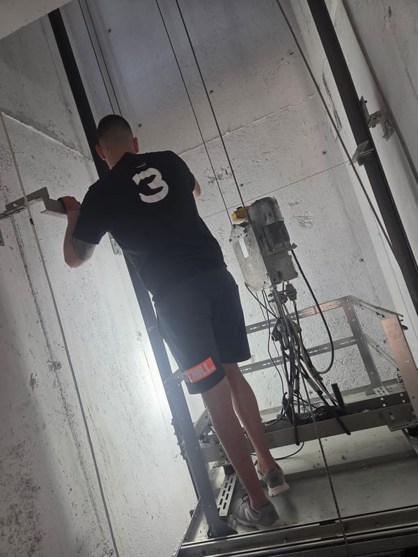 Maintenance work underway inside a suspended elevator shaft platform