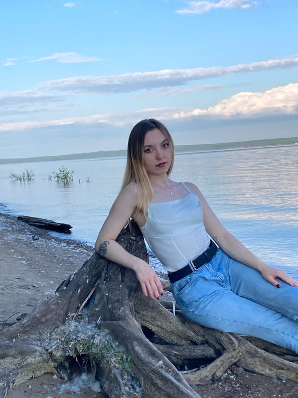 Woman poses for photos along waterfront in Noviy, Russia