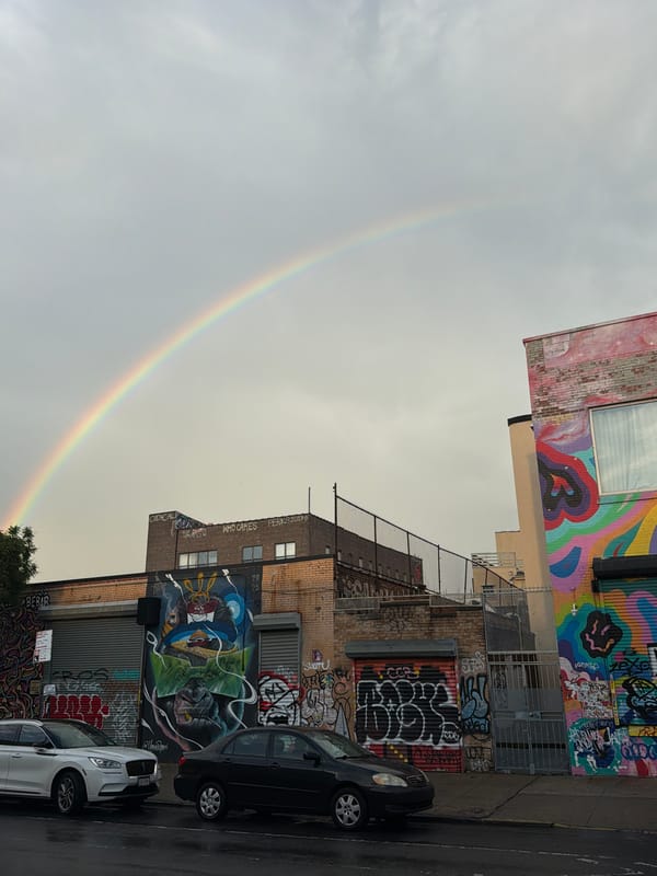 Rainbow appears over wet Brooklyn streets after evening rain