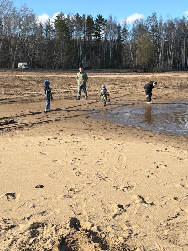 Four people gather in sandy forest area near Chaikovsky