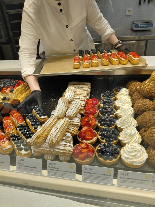 Fresh éclairs being prepped in a patisserie, plus a vintage Volga outside