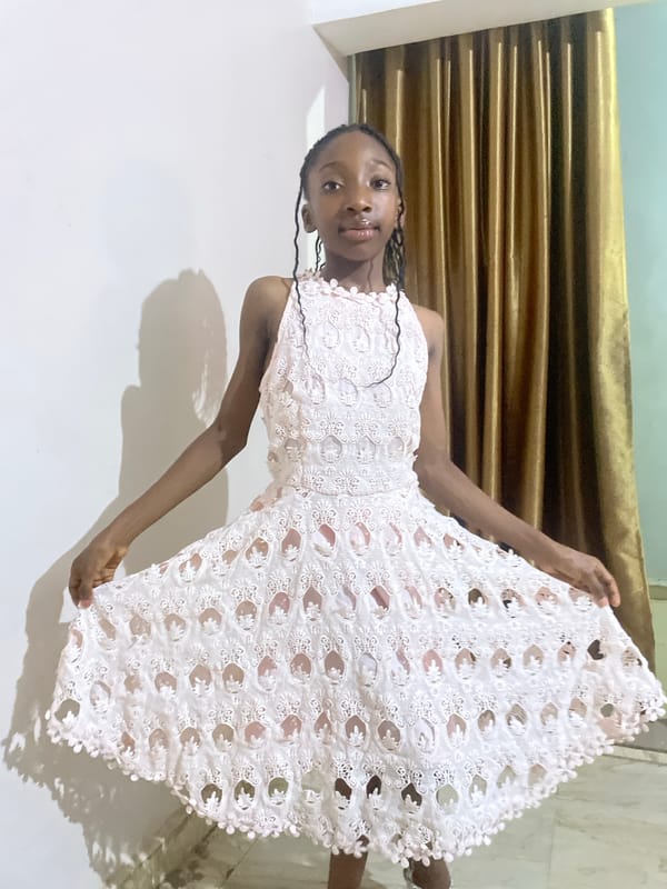 Woman poses with white lace dress in Jos home