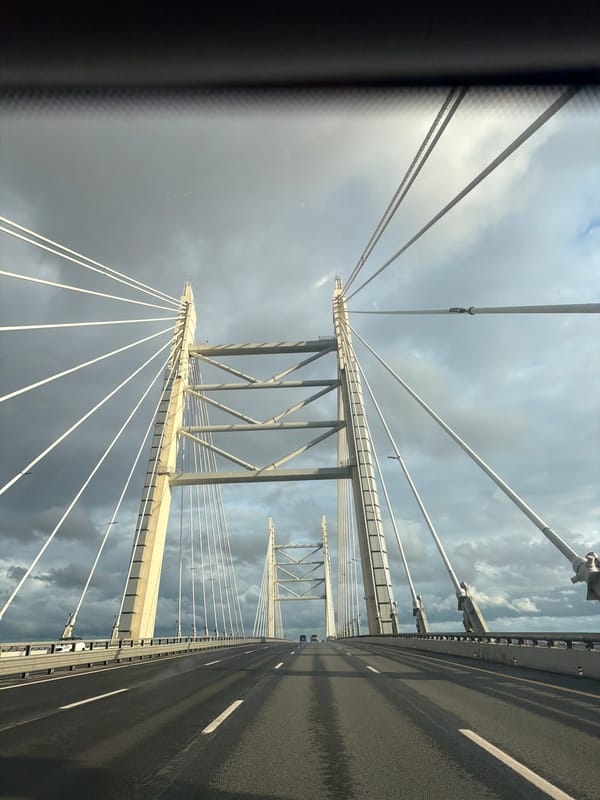On the road across a cable-stayed bridge under cloudy skies