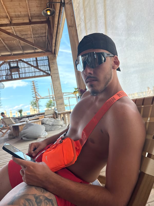 Lounging beachside in Sozopol with reflective shades and fanny pack